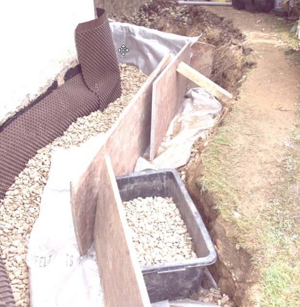 Freigelegte Drainage zur Trockenlegung einer Kellerwand