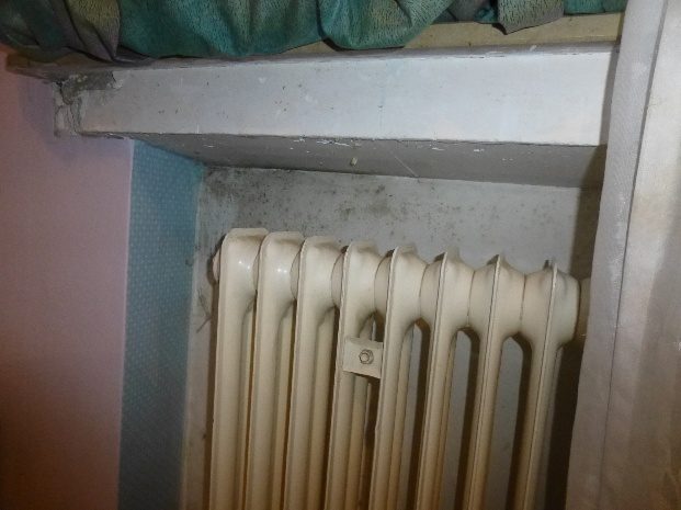 Feuchtigkeitsschaden an der Wand hinter einem Heizkörper